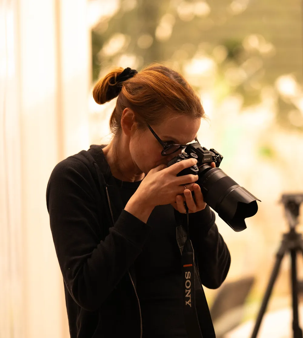 Patricia Iking mit ihrer Sony-Kamera am Auge, im warmen Gegenlicht