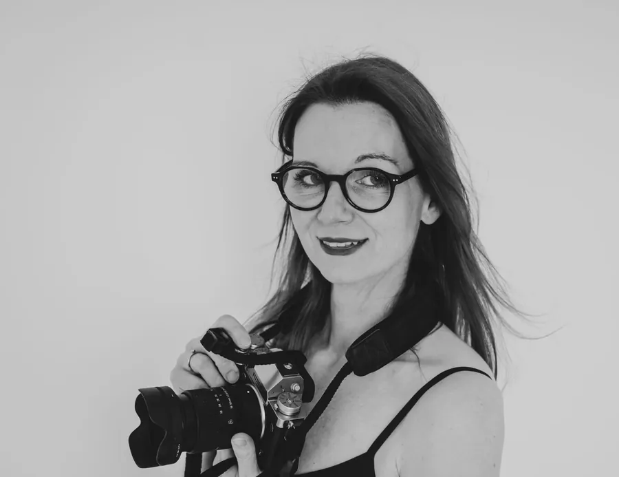 Schwarzweiß-Porträt von Patricia mit Kamera im Studio