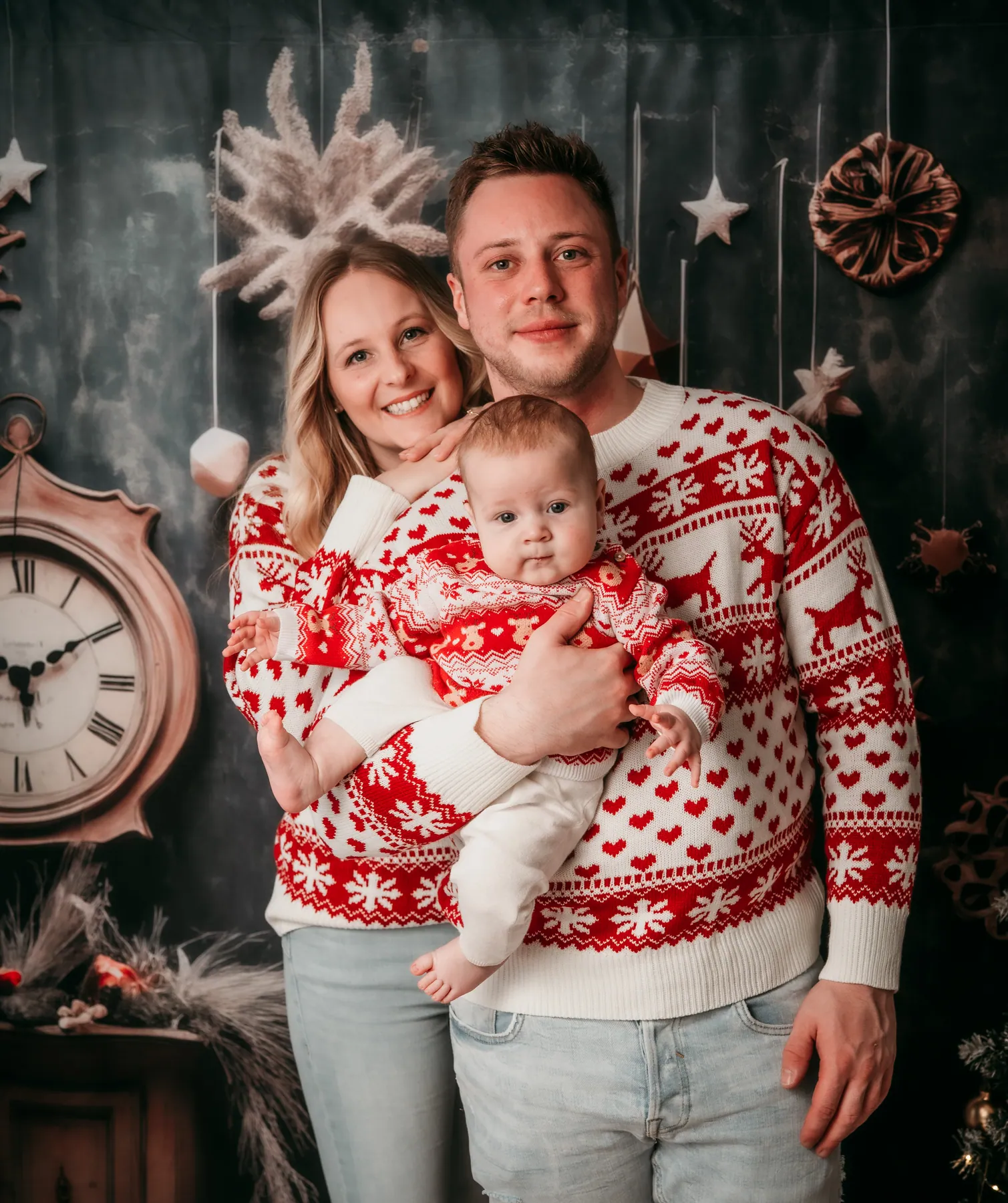 Familie in Weihnachtspullis vor der Winterkulisse